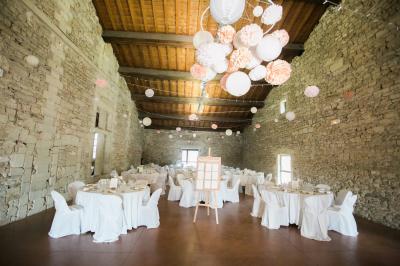 Terrasse en pierre spacieuse devant un bâtiment ancien en pierre sous un ciel bleu dégagé.