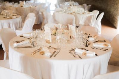 Terrasse en pierre spacieuse devant un bâtiment ancien en pierre sous un ciel bleu dégagé.