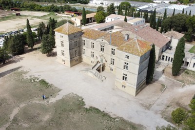 Miniature Location salle Vestric-et-Candiac (Gard) - Château de Vestric et Candiac #2 Vue aérienne d'un domaine avec un grand bâtiment principal, des annexes, un canal et des espaces verts environnants.