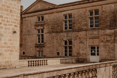 Miniature Location salle Vestric-et-Candiac (Gard) - Château de Vestric et Candiac #33 Vue aérienne d'un domaine avec un grand bâtiment principal, des annexes, un canal et des espaces verts environnants.