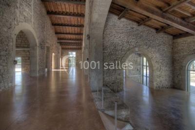 Terrasse en pierre spacieuse devant un bâtiment ancien en pierre sous un ciel bleu dégagé.