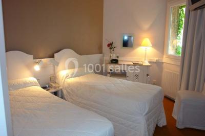 Salle de bain accessible avec douche à l'italienne, barres d'appui, lavabo adapté et toilettes surélevées.