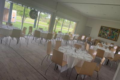 Salle de bain accessible avec douche à l'italienne, barres d'appui, lavabo adapté et toilettes surélevées.