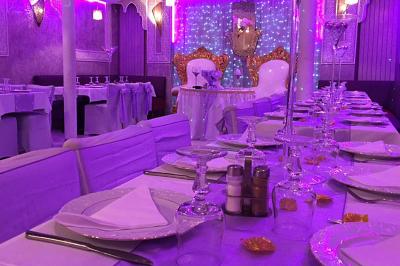 Buffet en extérieur sous un auvent, avec des fleurs et des arbres en arrière-plan.