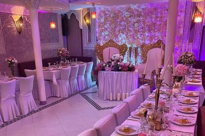 Buffet en extérieur sous un auvent, avec des fleurs et des arbres en arrière-plan.