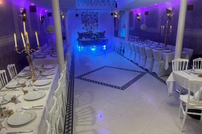 Buffet en extérieur sous un auvent, avec des fleurs et des arbres en arrière-plan.