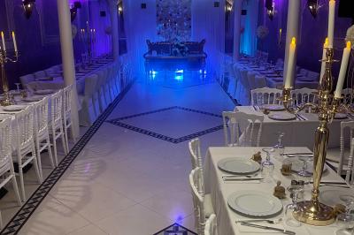 Buffet en extérieur sous un auvent, avec des fleurs et des arbres en arrière-plan.