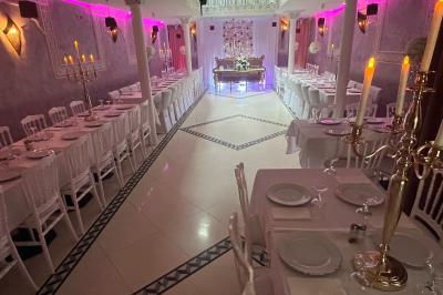 Buffet en extérieur sous un auvent, avec des fleurs et des arbres en arrière-plan.