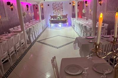 Buffet en extérieur sous un auvent, avec des fleurs et des arbres en arrière-plan.