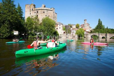 Salle de réunion lumineuse avec tables en U, chaises noires, grandes fenêtres donnant sur un jardin verdoyant.