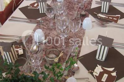 Salle de réunion lumineuse avec tables en U, chaises noires, grandes fenêtres donnant sur un jardin verdoyant.