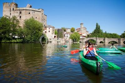 Salle de restaurant lumineuse avec tables dressées, bouteilles de vin, verres et décoration végétale.