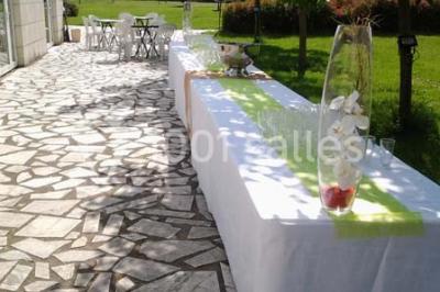 Chambre mansardée avec lit double, poutre apparente, télévision murale, commode, chaise et lampe de chevet.