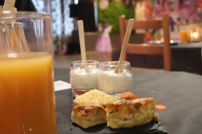 Assortiment de verrines et bouchées salées et sucrées sur un plateau, posé sur un comptoir en pierre.
