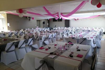 Deux lavabos blancs sur un meuble en bois avec miroirs, distributeur de savon mural et poubelle dans une salle de bain…