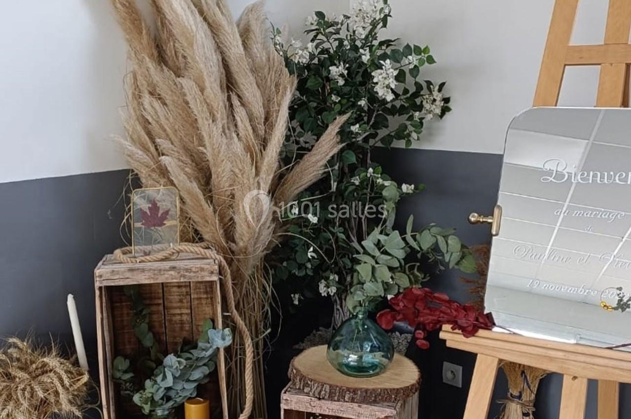 Décoration florale avec herbes de la pampa, feuillage, bougies et miroir sur chevalet dans un coin de pièce.