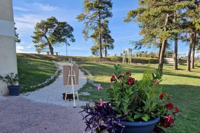 Deux lavabos blancs sur un meuble en bois avec miroirs, distributeur de savon mural et poubelle dans une salle de bain…