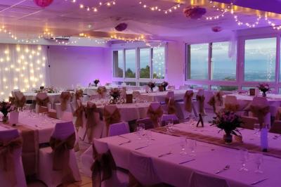 Deux lavabos blancs sur un meuble en bois avec miroirs, distributeur de savon mural et poubelle dans une salle de bain…