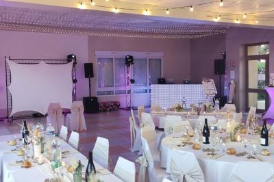 Deux lavabos blancs sur un meuble en bois avec miroirs, distributeur de savon mural et poubelle dans une salle de bain…