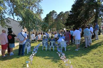 Deux lavabos blancs sur un meuble en bois avec miroirs, distributeur de savon mural et poubelle dans une salle de bain…