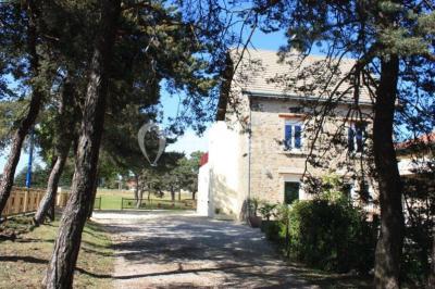 Deux lavabos blancs sur un meuble en bois avec miroirs, distributeur de savon mural et poubelle dans une salle de bain…