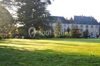 Étang calme reflétant des arbres et une pelouse verdoyante avec un bunker de golf en arrière-plan.
