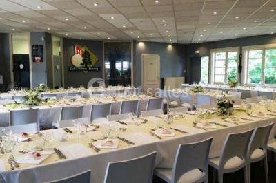 Étang calme reflétant des arbres et une pelouse verdoyante avec un bunker de golf en arrière-plan.