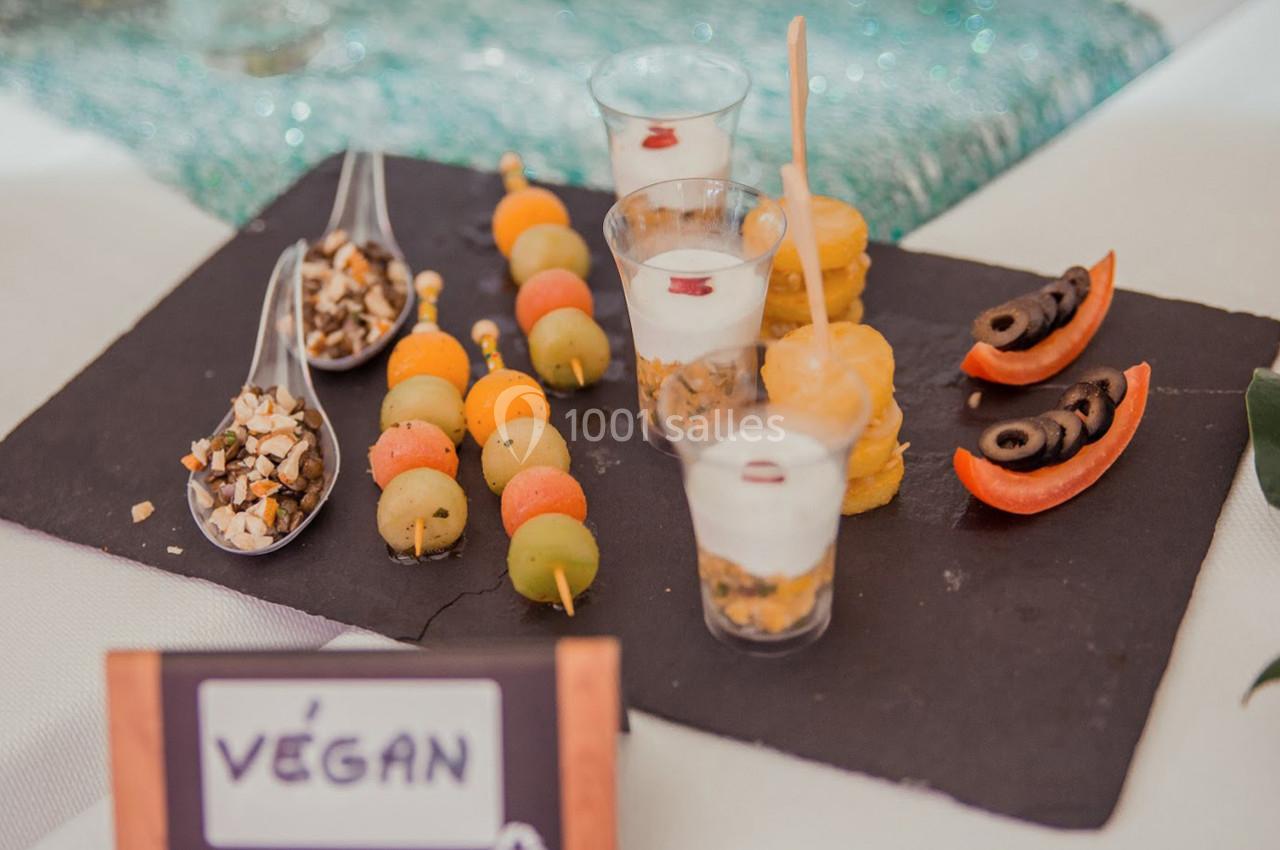 Plateau de dégustation avec verrines, brochettes de fruits, bouchées salées et garnitures végétaliennes.