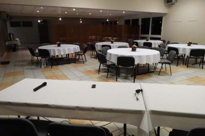 Bar lumineux blanc entouré de tabourets noirs et blancs dans une pièce avec vue sur une fenêtre en soirée.