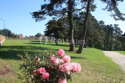 Bar lumineux blanc entouré de tabourets noirs et blancs dans une pièce avec vue sur une fenêtre en soirée.