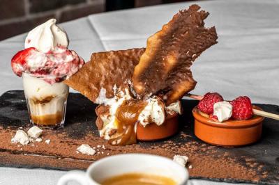 Dessert composé de crèmes brûlées, glace vanille avec coulis de fraise, framboises fraîches et tuiles au chocolat.