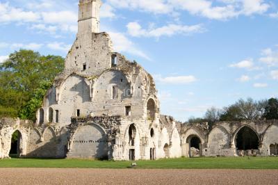 Intérieur d'une chapelle gothique avec des vitraux colorés, des voûtes ornées et des peintures murales détaillées.