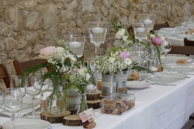 Tente en toile beige installée sur un sol gravillonné, entourée d'arbres, avec des lits aménagés à l'intérieur.