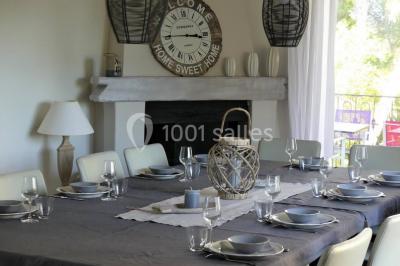 Tente en toile beige installée sur un sol gravillonné, entourée d'arbres, avec des lits aménagés à l'intérieur.