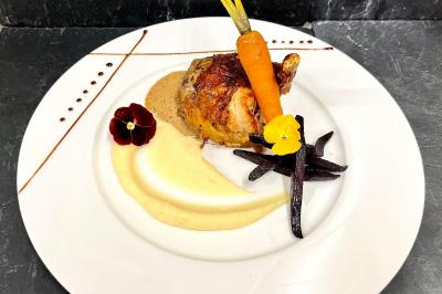 Allée pavée bordée de bougies allumées menant à une grande maison éclairée au crépuscule.