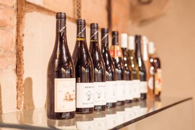 Allée pavée bordée de bougies allumées menant à une grande maison éclairée au crépuscule.