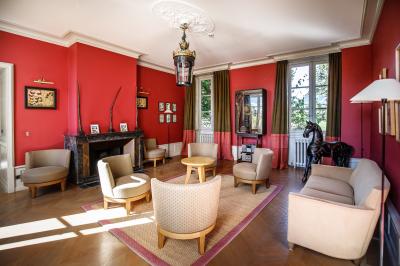 Allée pavée bordée de bougies allumées menant à une grande maison éclairée au crépuscule.