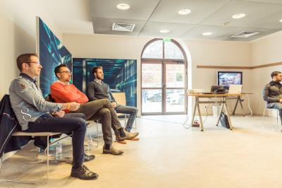 Allée pavée bordée de bougies allumées menant à une grande maison éclairée au crépuscule.