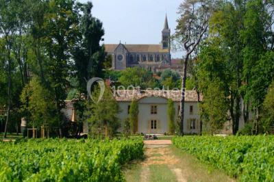 Allée pavée bordée de bougies allumées menant à une grande maison éclairée au crépuscule.