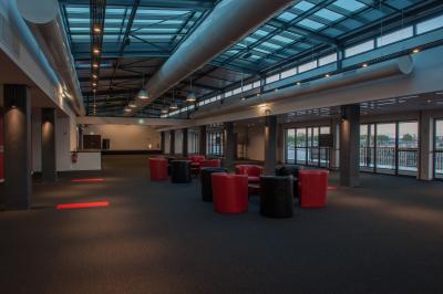 Vue nocturne d'une terrasse éclairée en bleu avec une rivière et un pont illuminé en arrière-plan.
