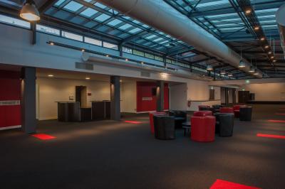 Vue nocturne d'une terrasse éclairée en bleu avec une rivière et un pont illuminé en arrière-plan.
