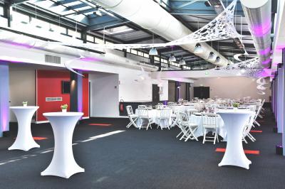 Vue nocturne d'une terrasse éclairée en bleu avec une rivière et un pont illuminé en arrière-plan.