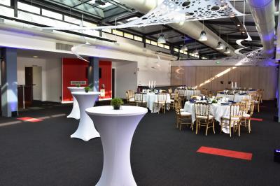 Vue nocturne d'une terrasse éclairée en bleu avec une rivière et un pont illuminé en arrière-plan.