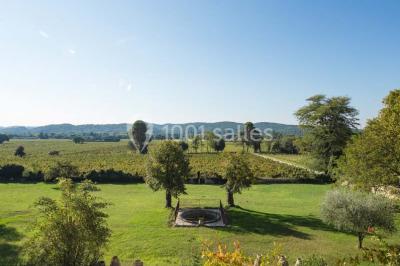 Tables rondes dressées avec nappes blanches et décorations, disposées en extérieur sur une terrasse ensoleillée.