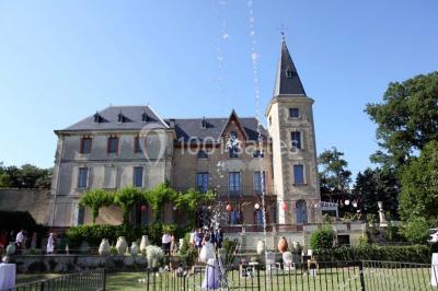 Tables rondes dressées avec nappes blanches et décorations, disposées en extérieur sur une terrasse ensoleillée.