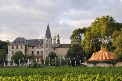 Tables rondes dressées avec nappes blanches et décorations, disposées en extérieur sur une terrasse ensoleillée.