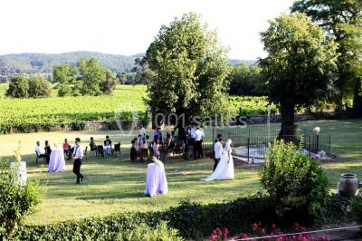 Tables rondes dressées avec nappes blanches et décorations, disposées en extérieur sur une terrasse ensoleillée.