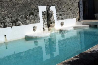 Tables rondes dressées avec nappes blanches et décorations, disposées en extérieur sur une terrasse ensoleillée.