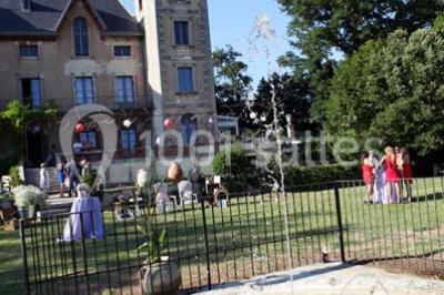Tables rondes dressées avec nappes blanches et décorations, disposées en extérieur sur une terrasse ensoleillée.