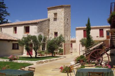 Un couple en tenue de mariage pose devant un groupe de cavaliers alignés sur des chevaux dans un espace verdoyant.